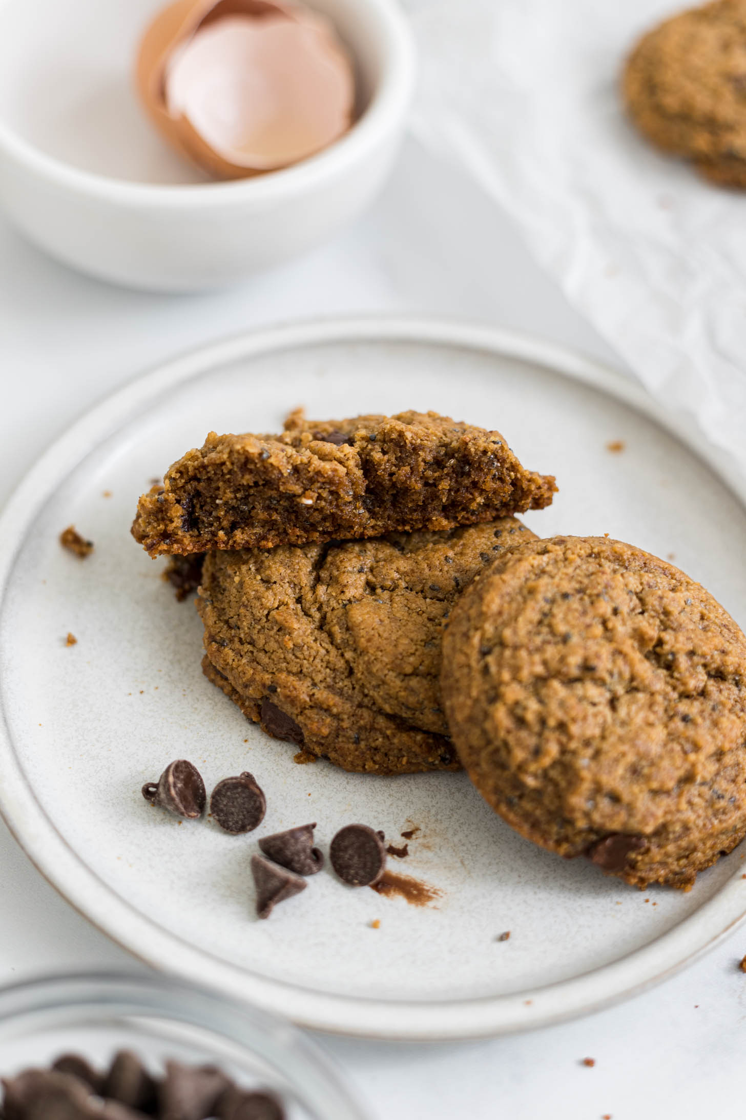 A peanut butter cookie broken in half resting on top of cookies.