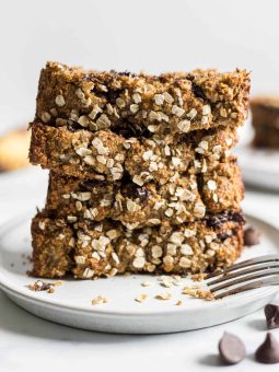 A stack of Gluten-Free Chocolate Chip Oatmeal Banana Bread slices on a plate.