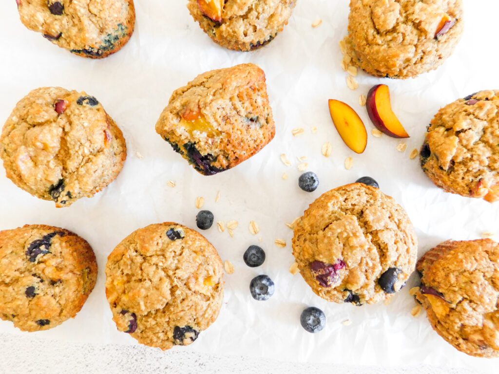 Blueberry nectarine muffins with blueberries and nectarines next to them,