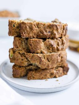 A stack of zucchini banana bread slices on a small plate.