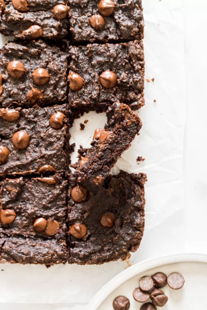 An overhead view of chickpea brownies with one brownie standing on it's side.