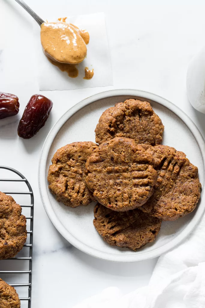 An overhead view of a plate of cookies with dates beside it.