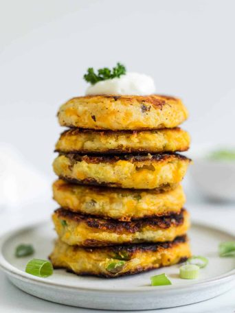 A large stack of mashed potato pancakes on a plate.