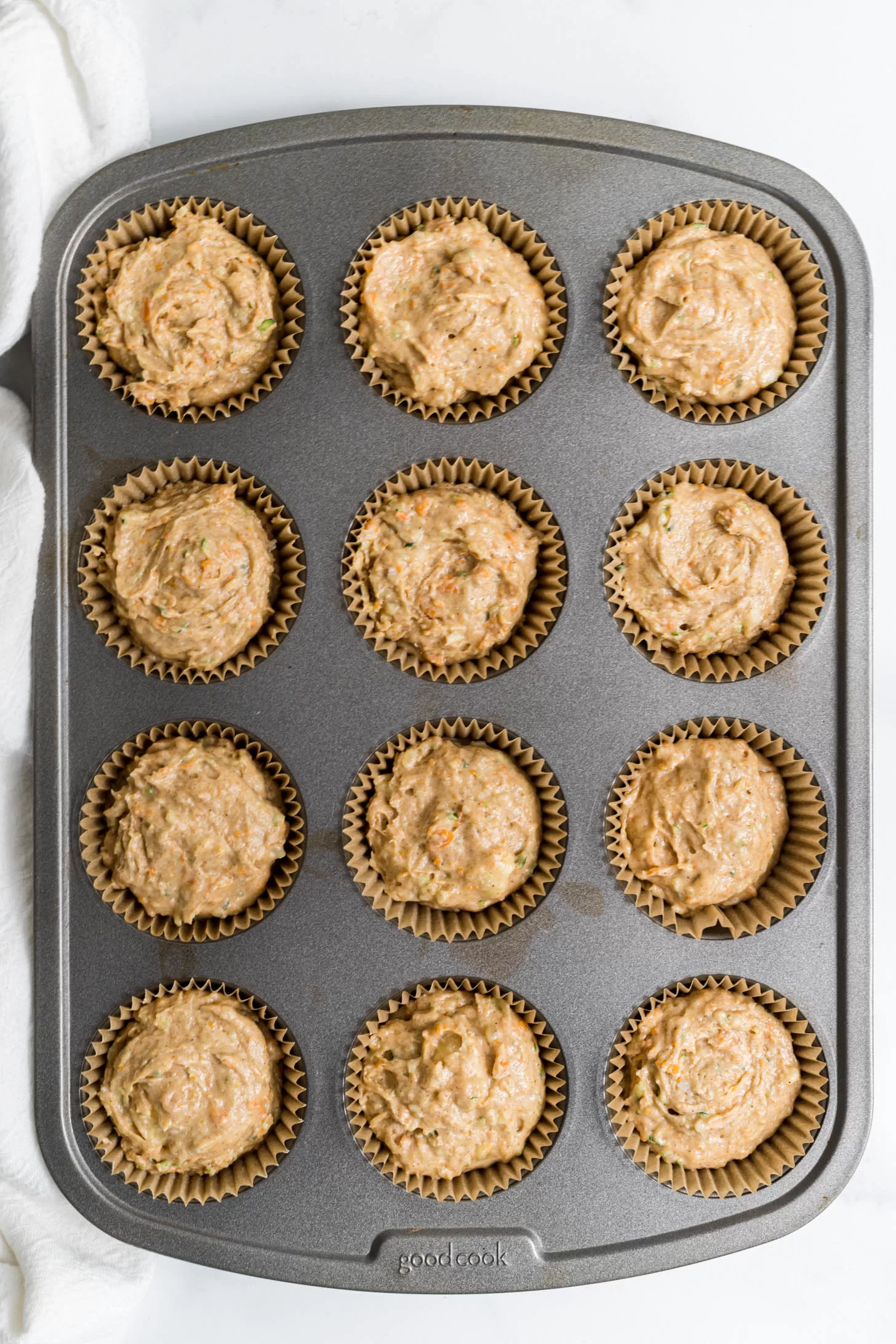 Uncooked muffins in a muffin tin.