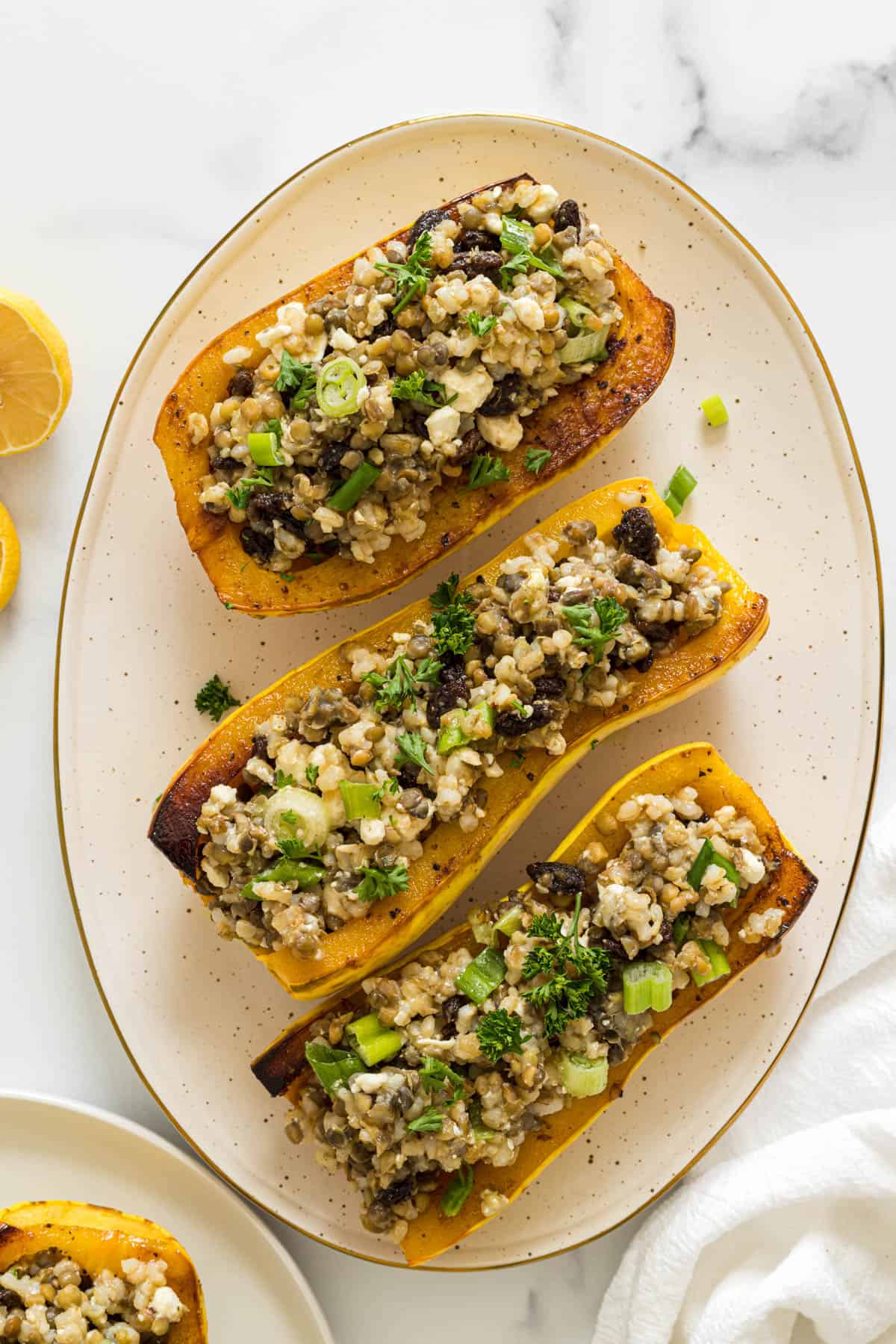 Overhead view of three delicata squash boats on a plate.