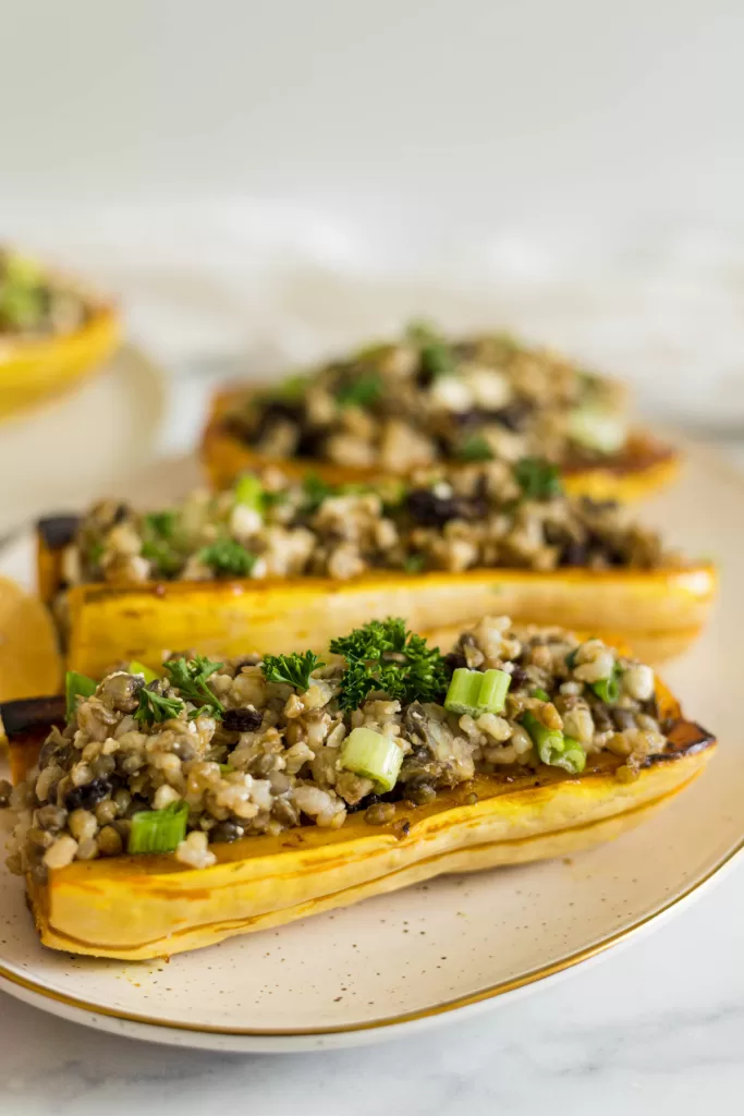 A side view of vegetarian stuffed delicata squash on a plate.