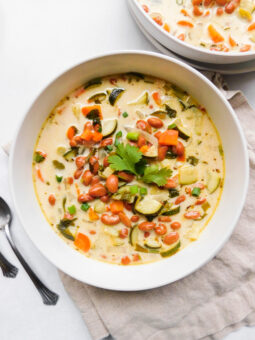 A bowl of Quick Vegan Pinto Bean Soup. Another bowl of soup sits off to the side and some spoons.