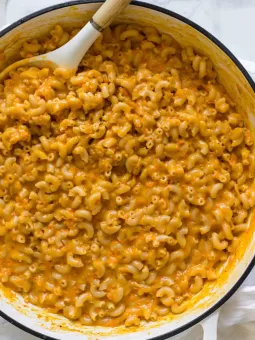 Healthy Mac and Cheese is in a big white pan with a serving spoon in it.