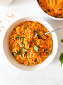 A bowl of Red Lentil Curry With Sweet Potato and Spinach.