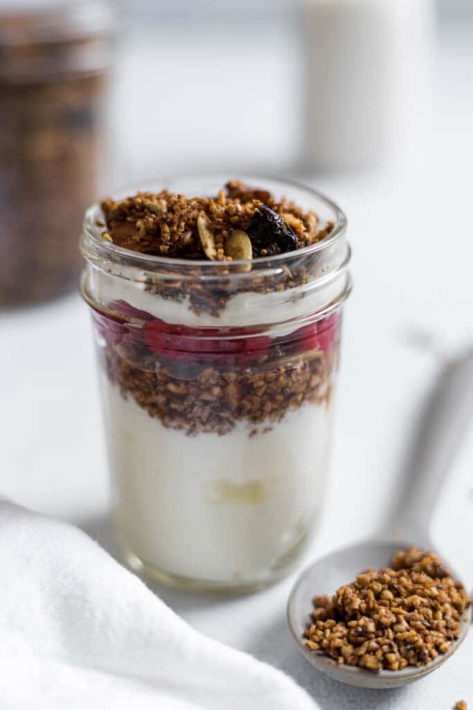 A yogurt parfait with steel-cut oat granola and raspberries in it.