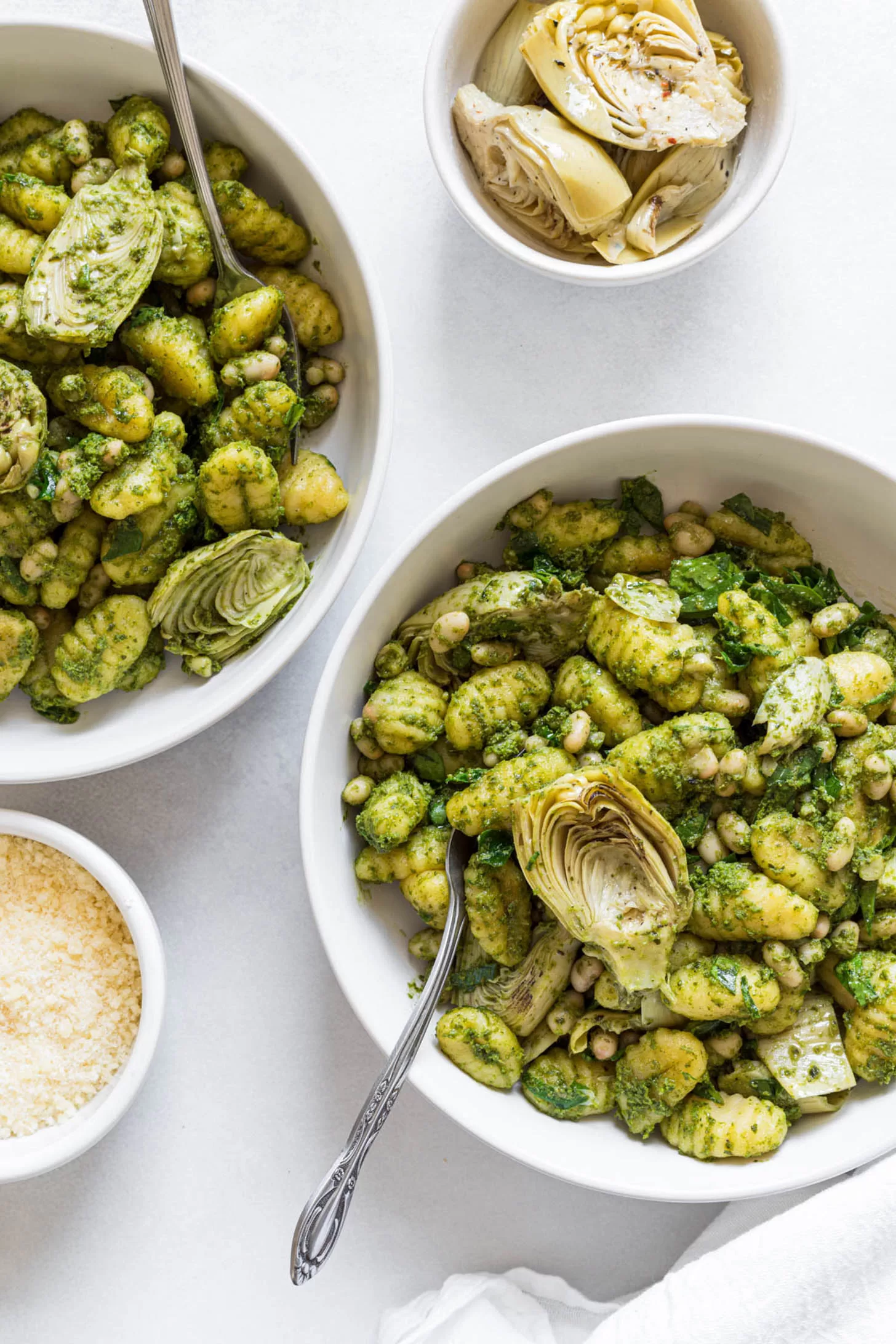 Pesto gnocchi in two serving bowls.