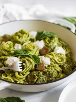 A side view of Pesto Ricotta Pasta in a braiser. A fork is turning some pasta.