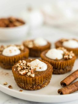 Healthy Pumpkin Tarts on a plate with cinnamon sticks next to it.