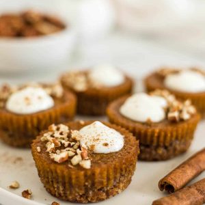 Healthy Pumpkin Tarts on a plate with cinnamon sticks next to it.