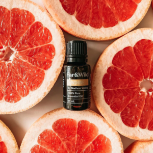 An essential oil bottle with grapefruit surrounding it.