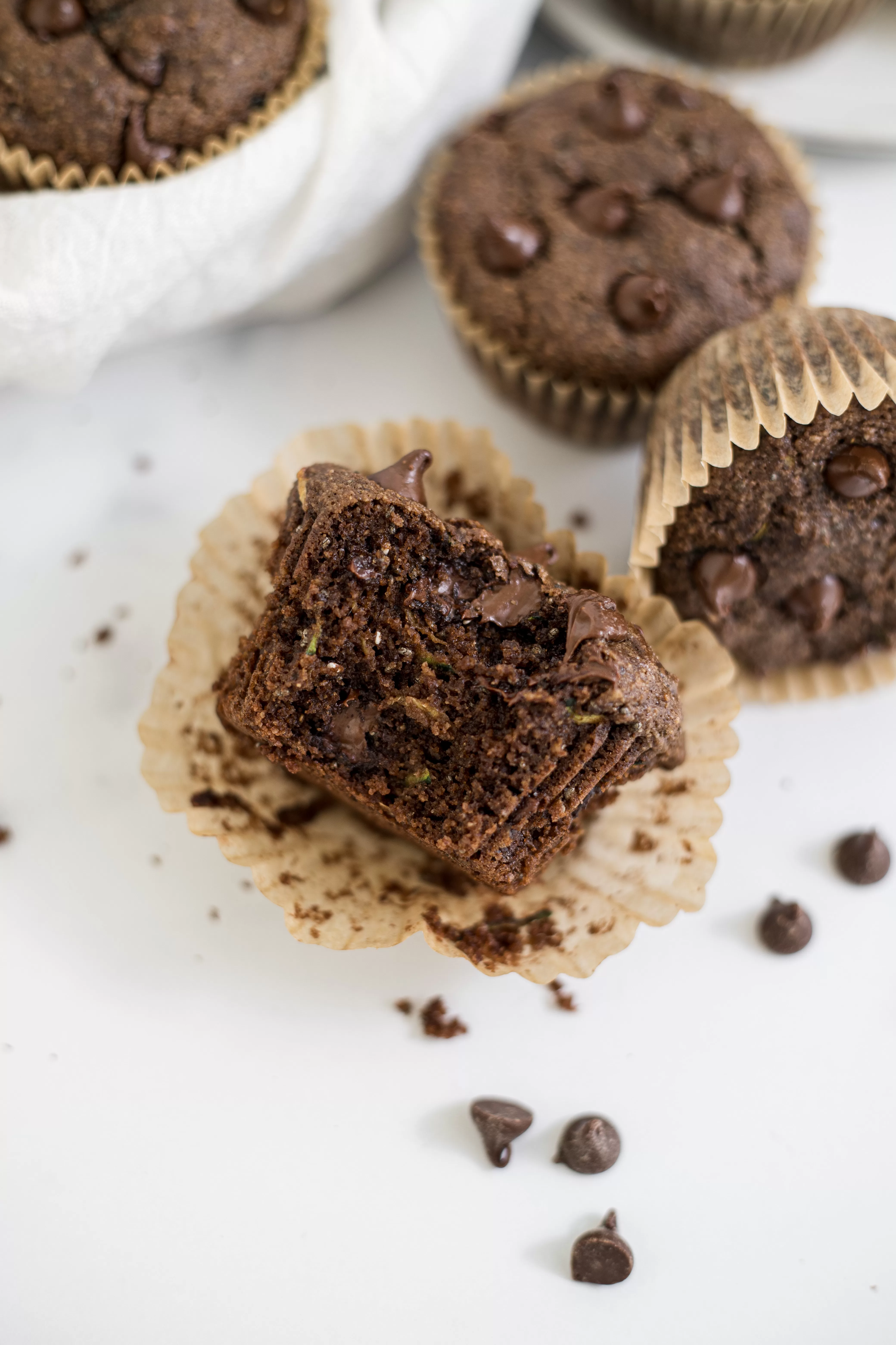 A chocolate zucchini muffin with a bite out of it.