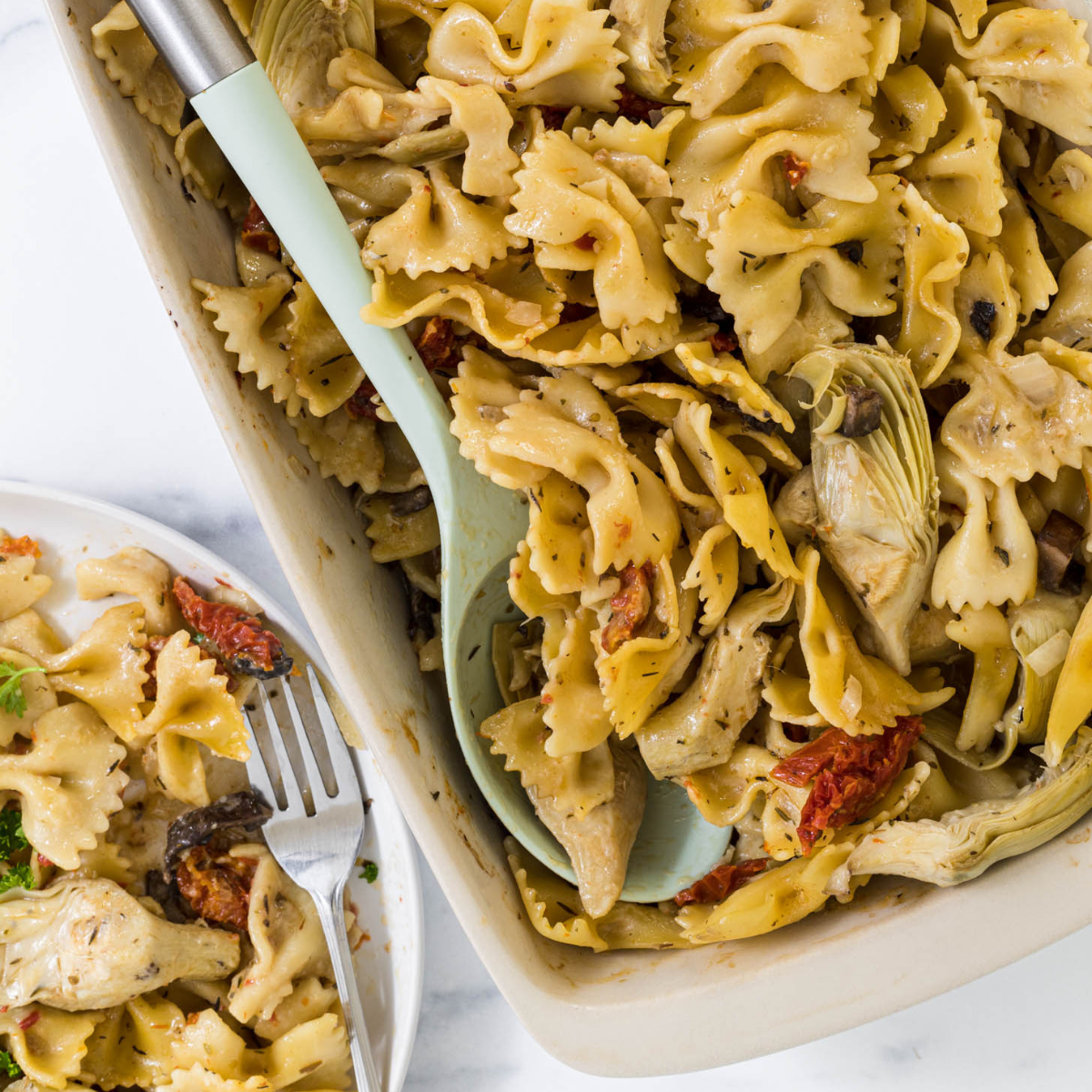 Artichoke and sundried tomato pasta in a casserole dish.