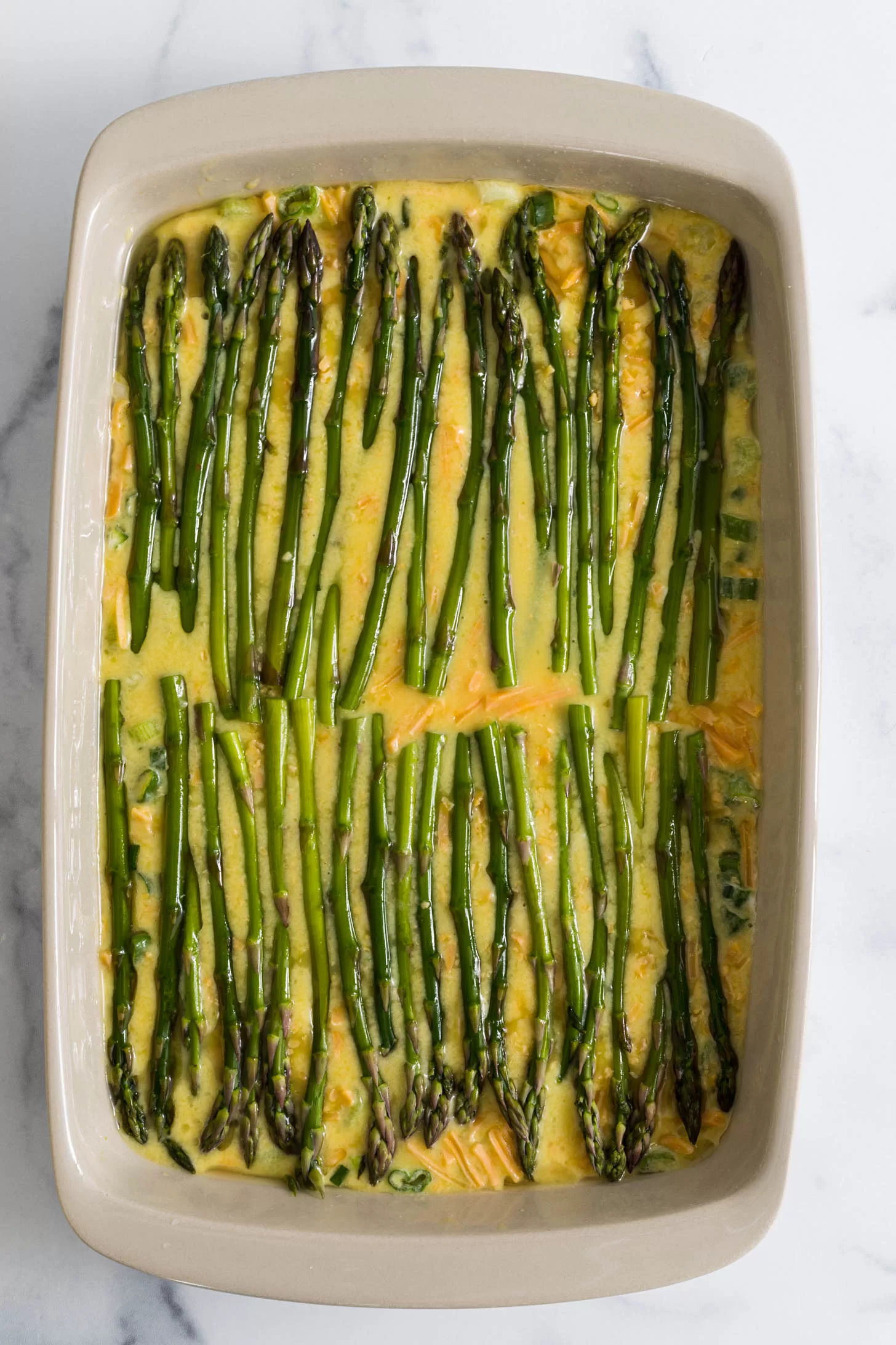 Asparagus spears lined up on top of egg casserole.