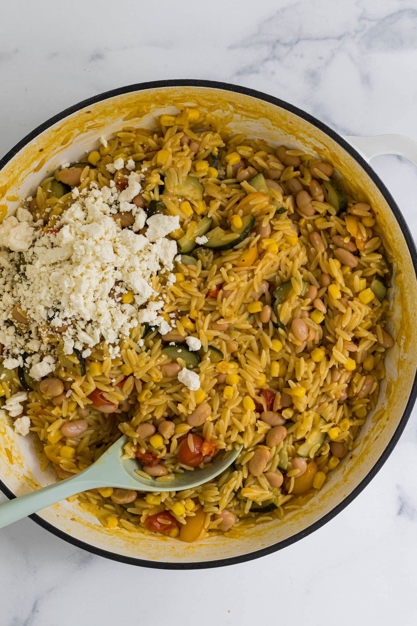 Parmesan cheese and feta cheese are added to the pot.