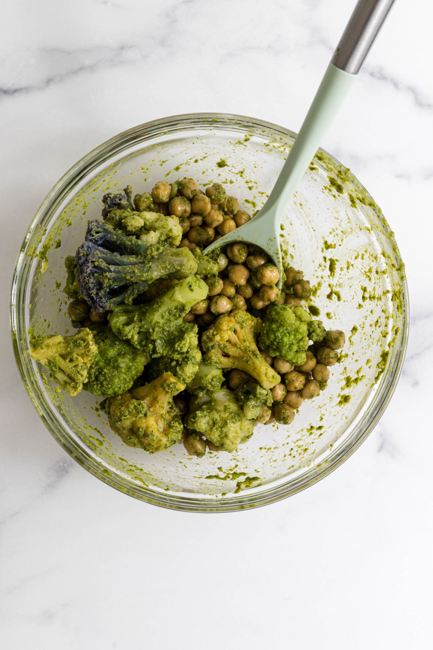 Chickpeas, cauliflower, and pesto mixed in a bowl.