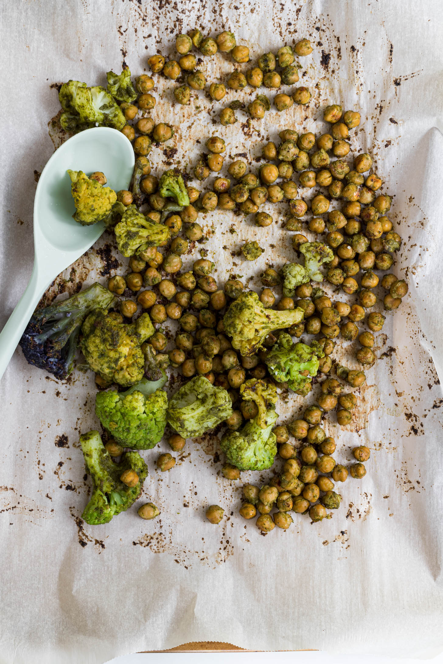 Roasted chickpeas with pesto on a baking tray.