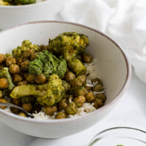 A bowl of rice topped with roasted pesto chickpeas.