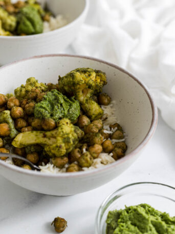 A bowl of rice topped with roasted pesto chickpeas.