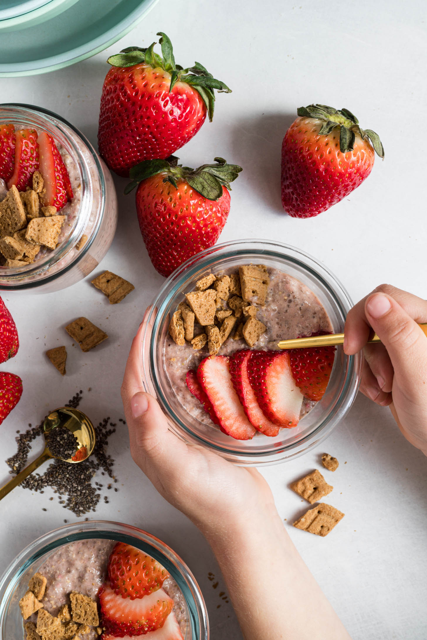 Strawberry pudding with a kid's hands on the bowl.
