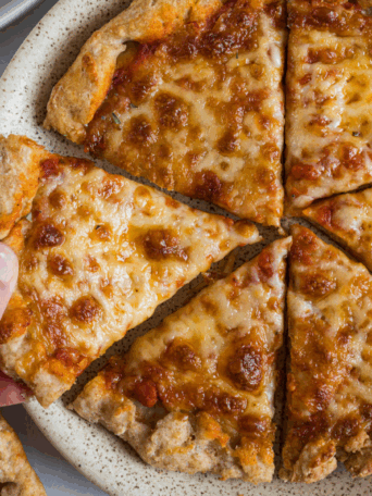 Protein pizza on a plate being served.