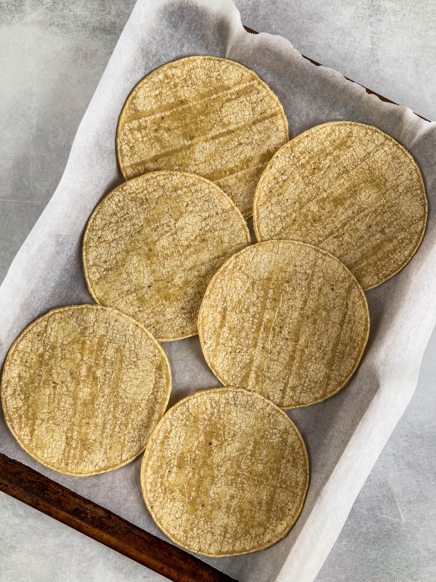 Corn tortillas on a baking sheet.