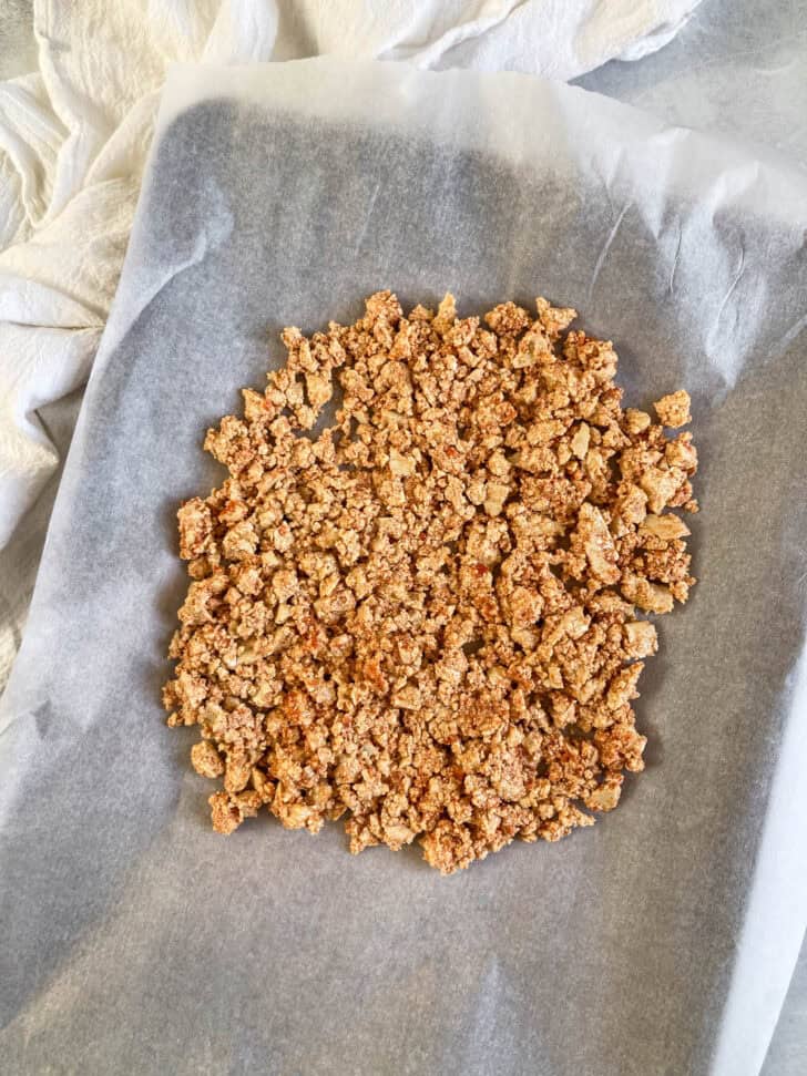 Pizza tofu crumbles laid out on a baking sheet.