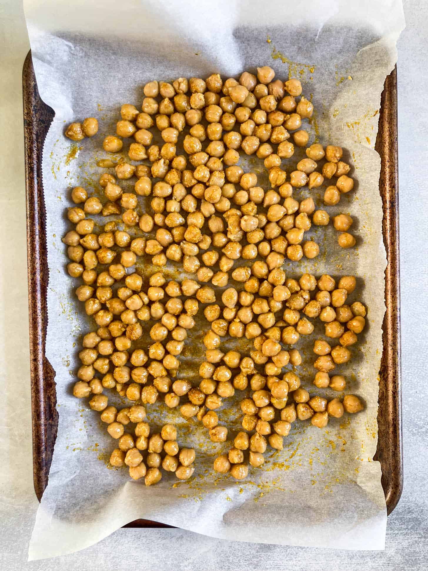 Seasoned chickpeas on a baking sheet.