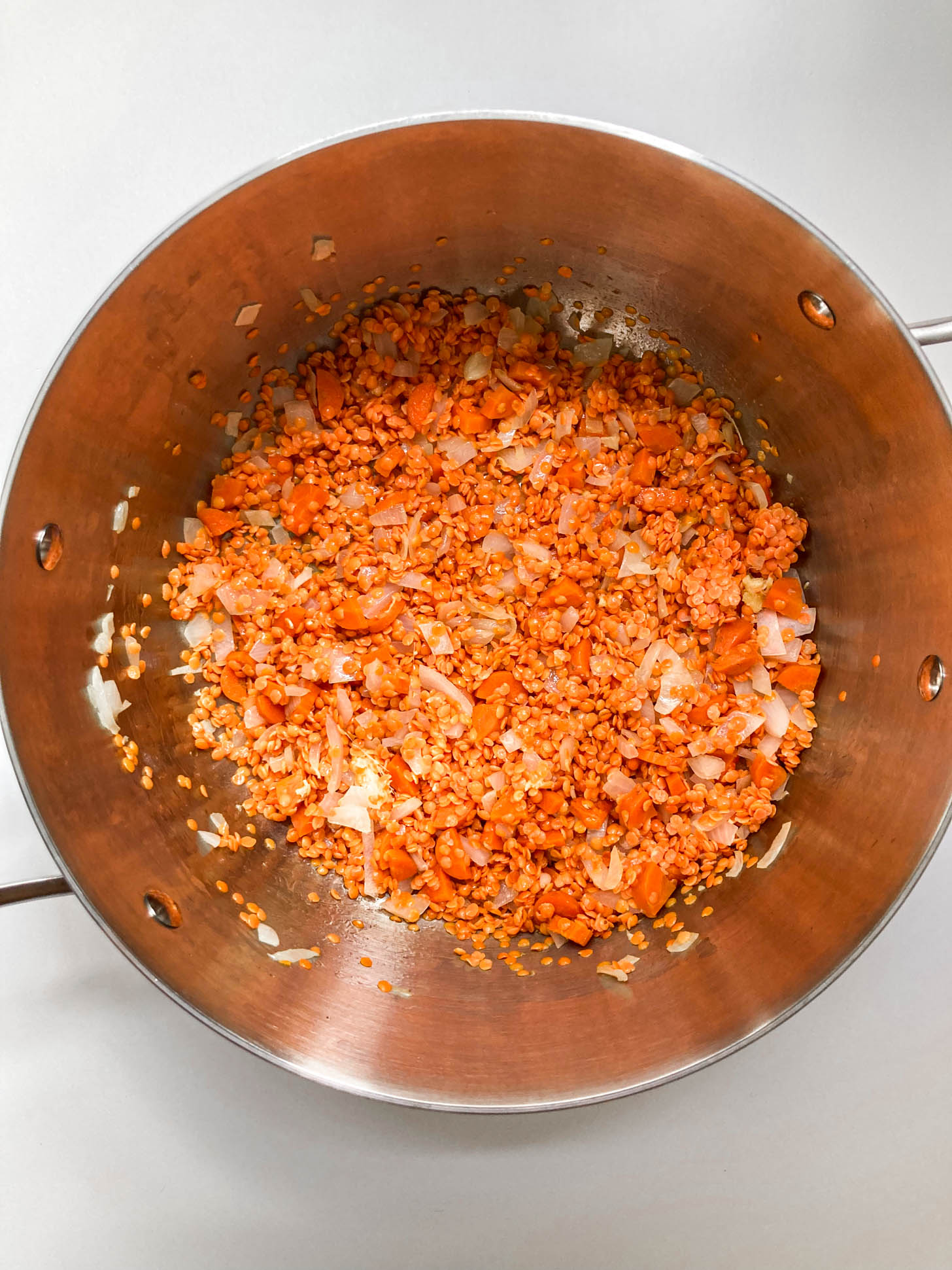 Lentils and garlic mixed into the pot.