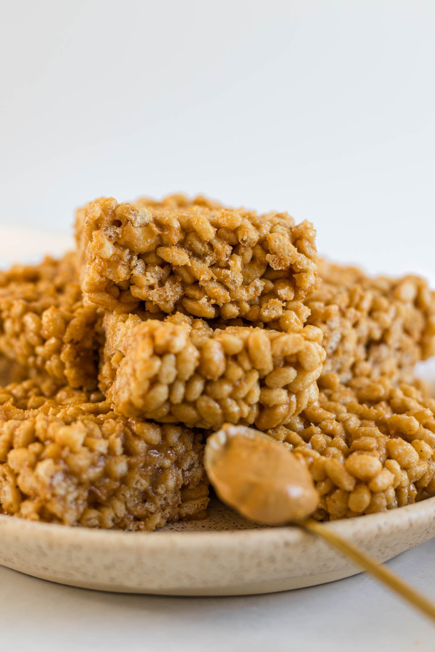 Peanut butter rice krispie treats stacked on a plate.