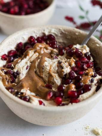 A greek yogurt bowl with pomegranate and almond butter.