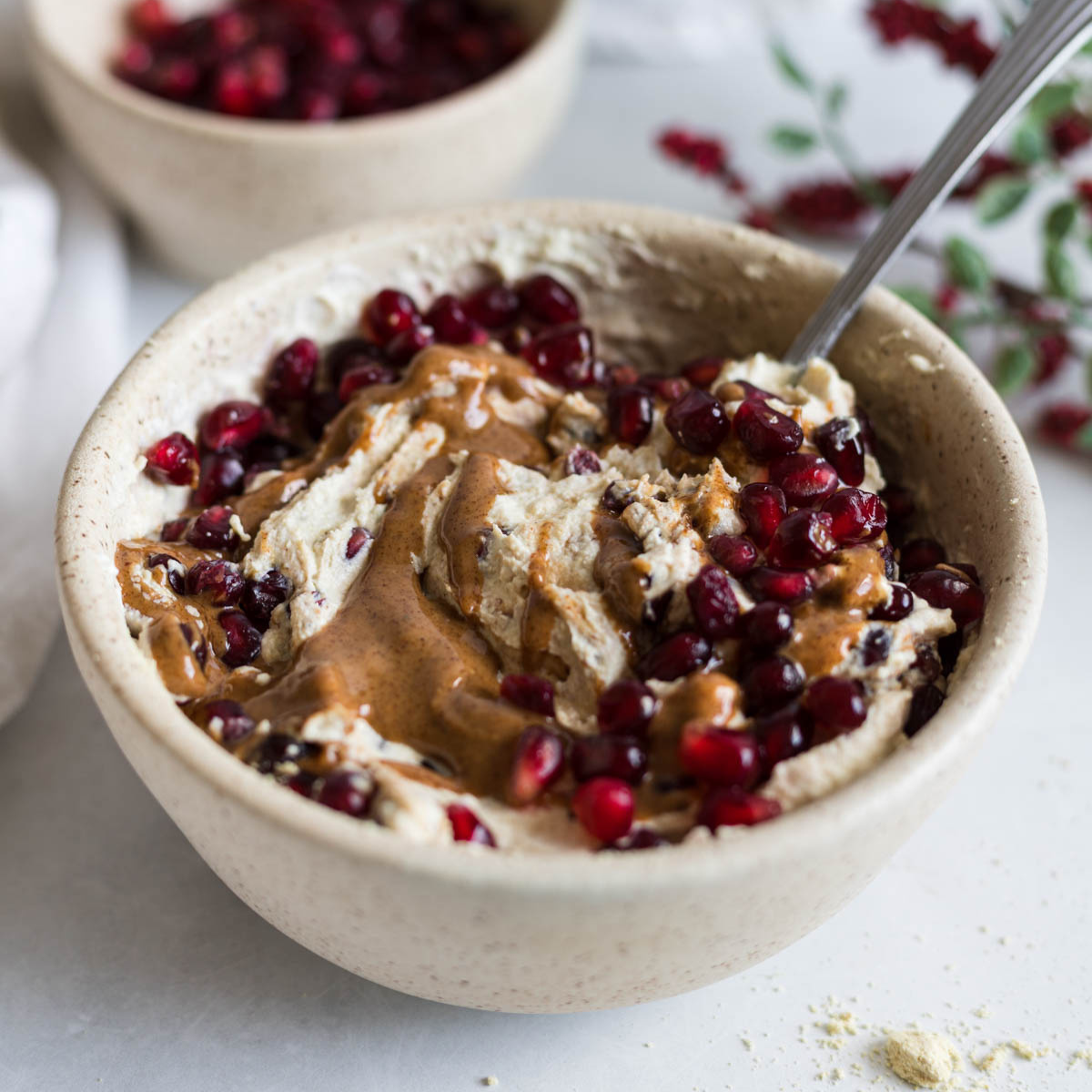 A greek yogurt bowl with pomegranate and almond butter.