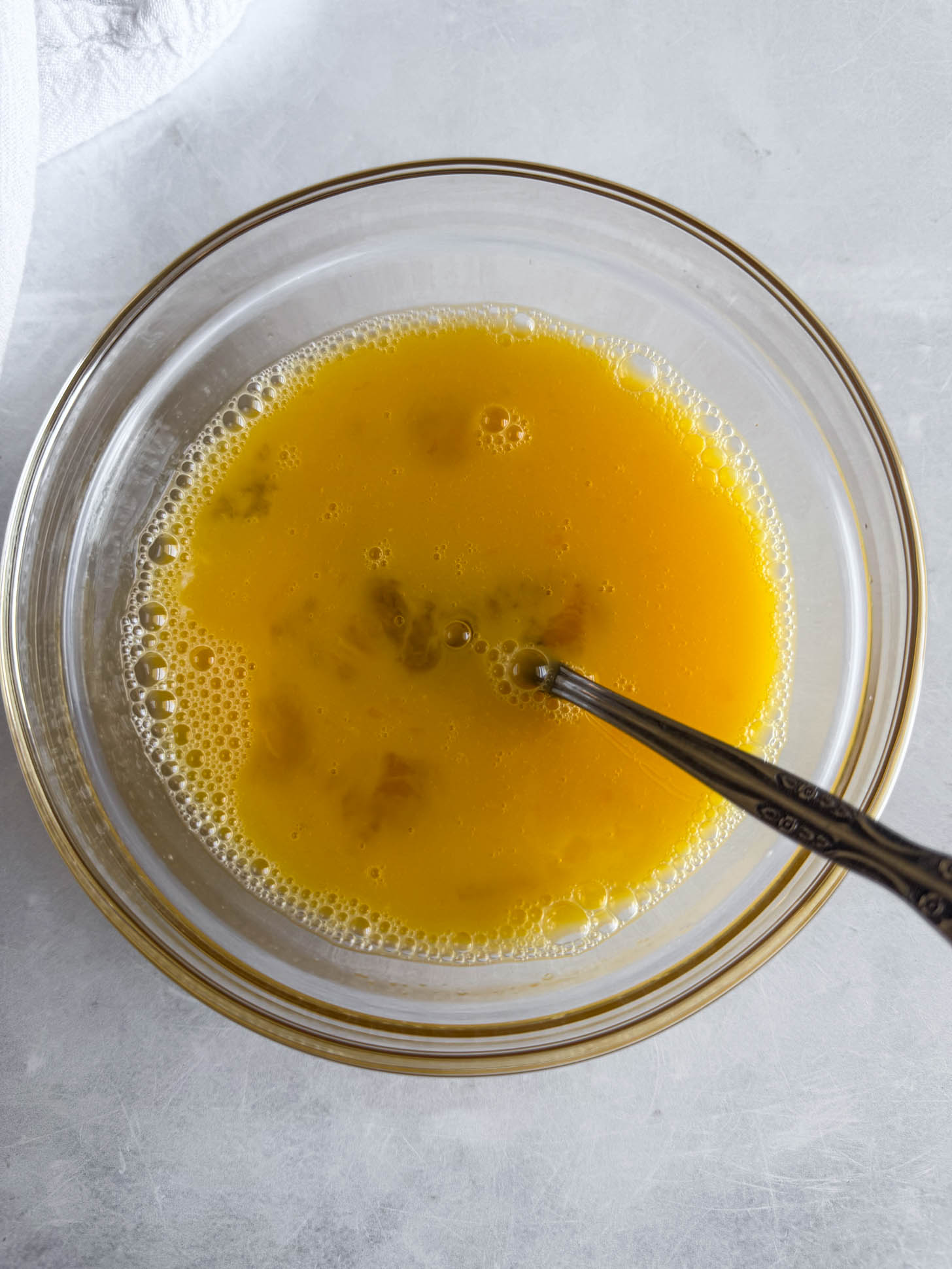 Eggs whisked in a bowl.