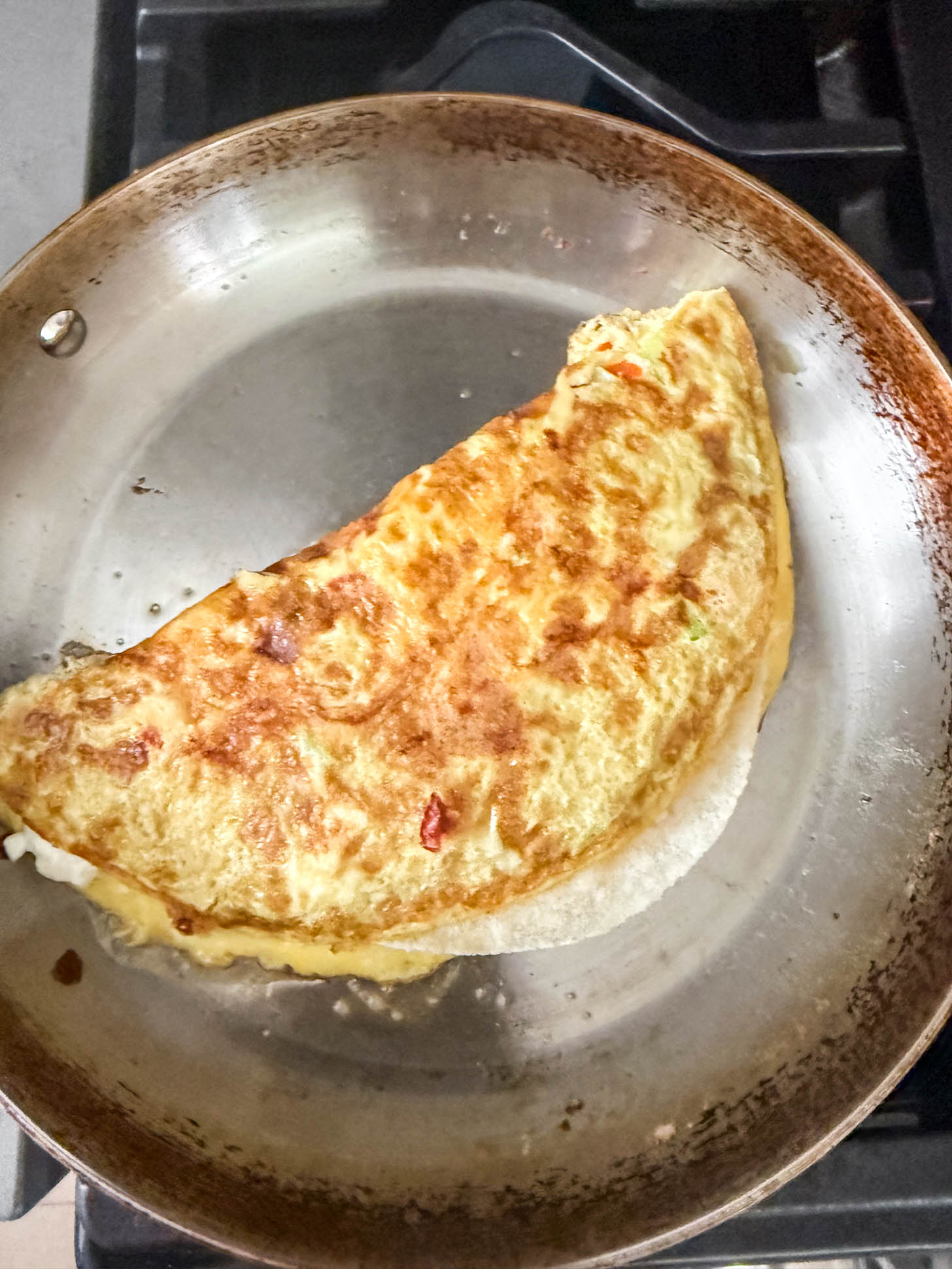 Omelette flipped in half in a pan.